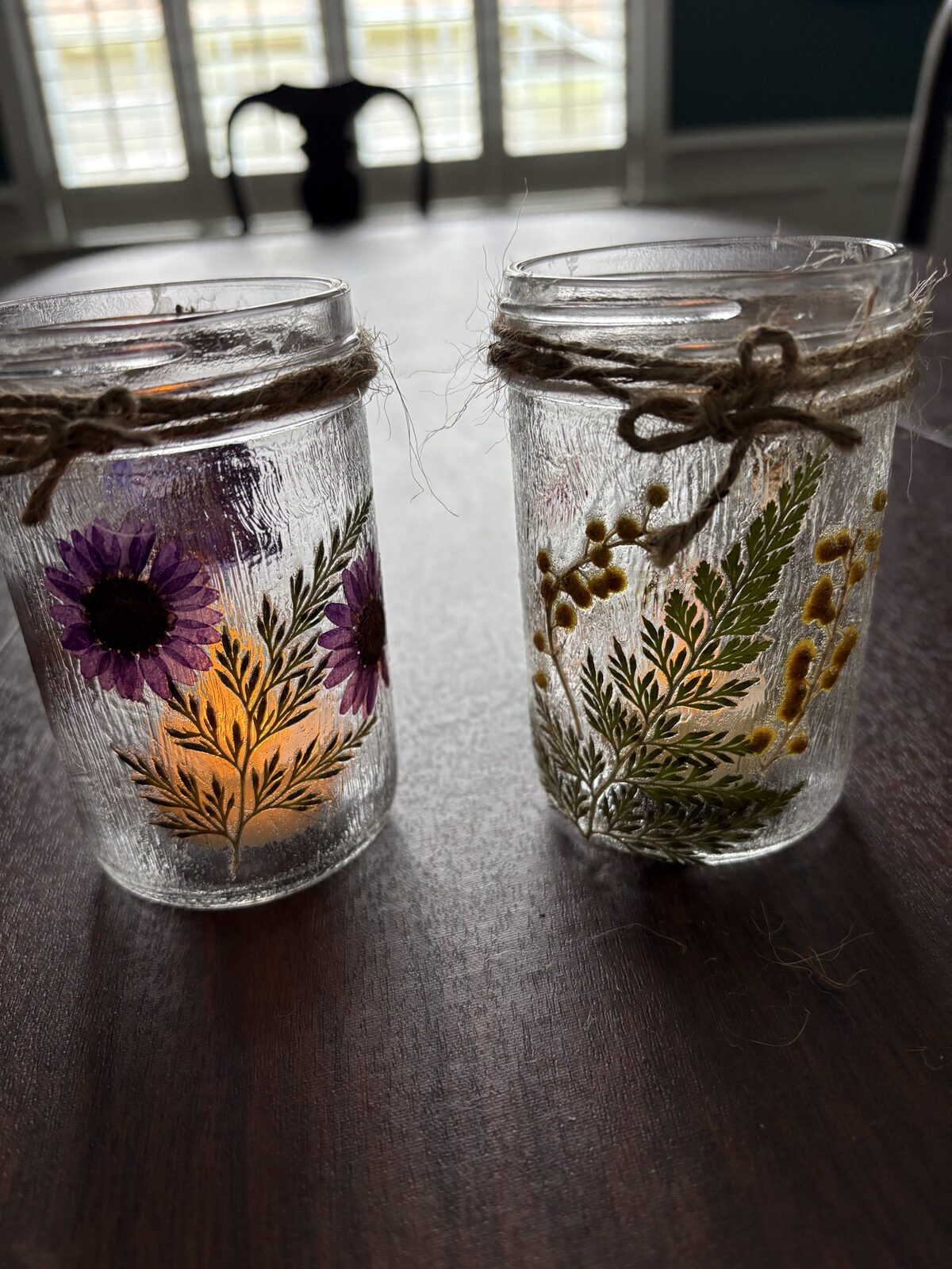 Two pressed flower jars tied with twine